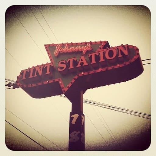 The original Johnny’s Tint Station roadside sign on Highway 98